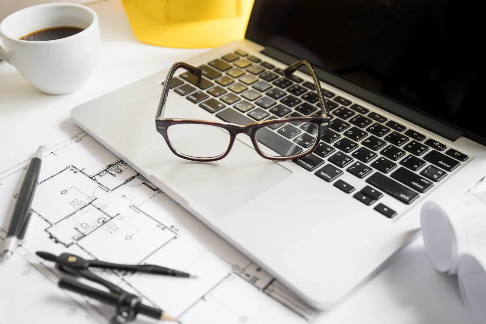 Laptop und Brille auf dem Schreibtisch